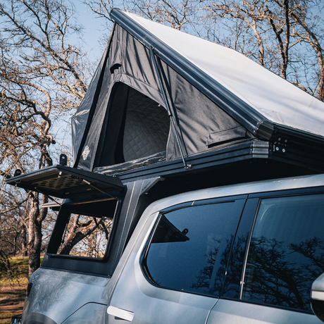 Front three-quarter view of Rivian R1T with aluminum pop-up camper