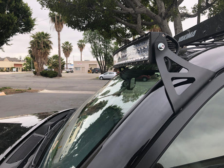 Close-up of curved LED light bar and roof mounting brackets on Toyota 4Runner - Cali Raised LED